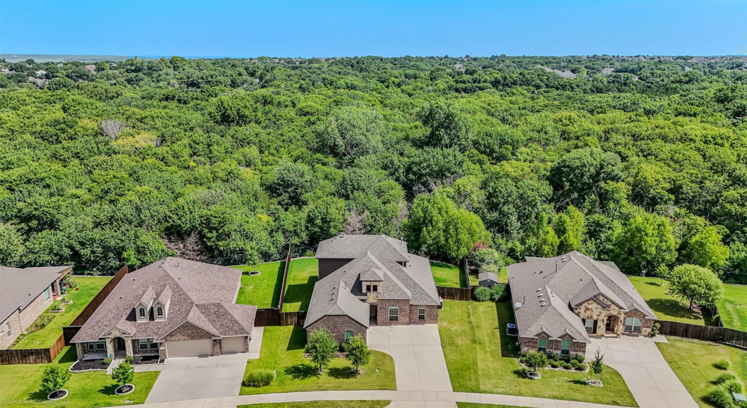 Aerial view of new brick homes in a wooded Rockwall County, TX neighborhood