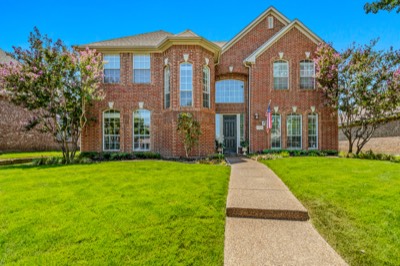 Brick home front elevation with aggregate walkway and arched windows