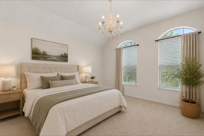 Carpeted primary bedroom with upholstered king bed and arched windows