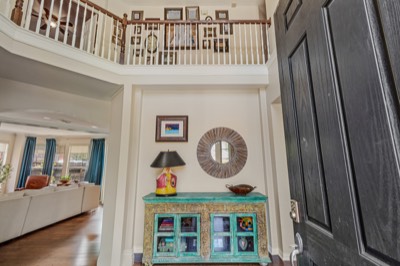 Two-story foyer with black front door and painted console table