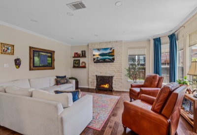 Living room with sectional sofa, leather recliners, and stacked-stone gas fireplace