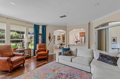 Open living room with sofa and recliners, view toward kitchen and dining