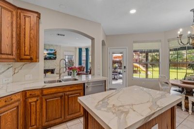 Kitchen island and sink with door and windows overlooking backyard playset