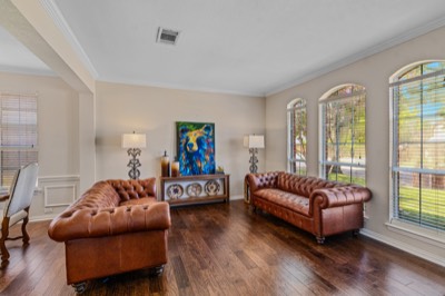Formal living room with leather sofas and arched windows