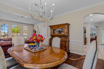 Dining room with oval wood table, hutch, and floral centerpiece